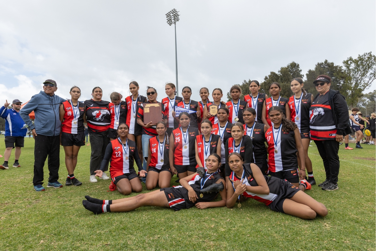 Mullewa Saints Youth Girls with coach Uncle Charlie Comeagain, Shooting Stars Regional Manager, Lauren Seelander, coach Cassie Comeagain, and Team Manager Aunty Denise Garlett, photographed by Jesse Pickett 